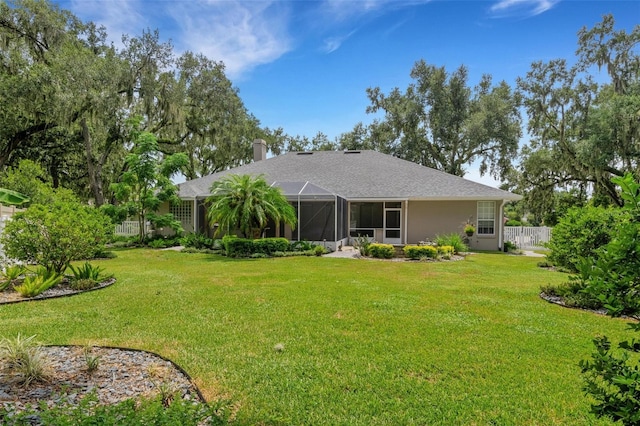 rear view of house featuring a yard and a lanai