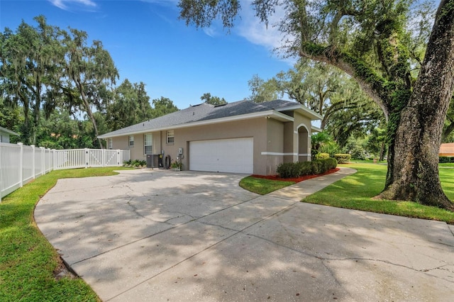 ranch-style home featuring central AC, a front yard, and a garage