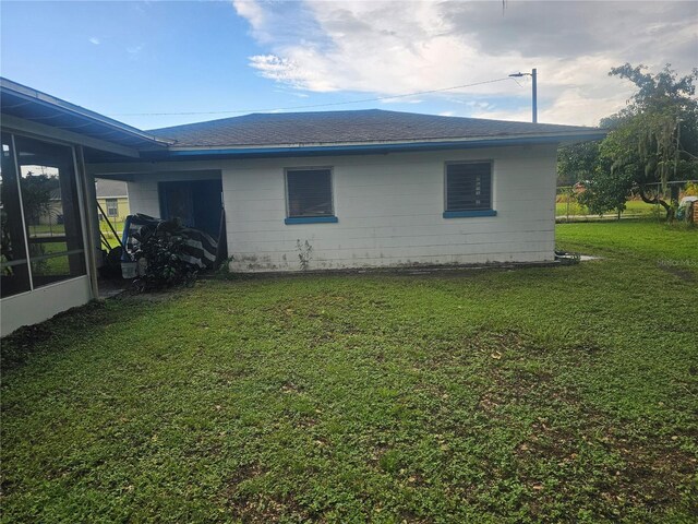 view of property exterior featuring roof with shingles and a yard