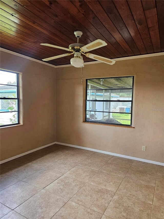 empty room with wooden ceiling, light tile patterned floors, baseboards, and a ceiling fan