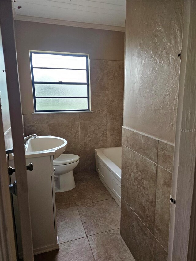 bathroom featuring a tub to relax in, crown molding, tile walls, toilet, and vanity