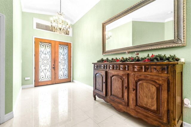 entryway featuring baseboards, lofted ceiling, ornamental molding, french doors, and a notable chandelier