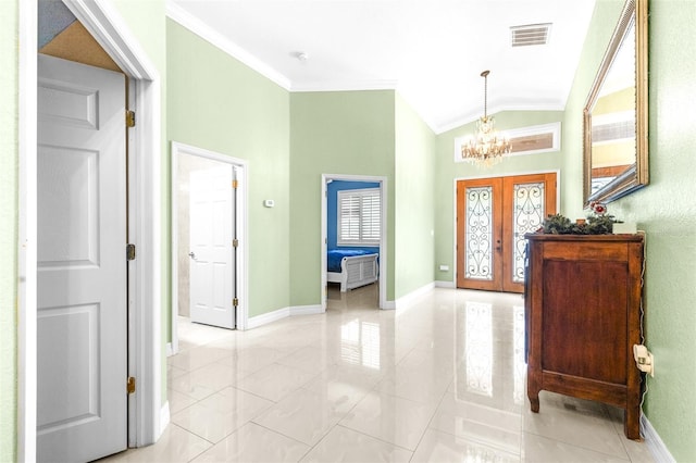 foyer with baseboards, lofted ceiling, french doors, crown molding, and a notable chandelier