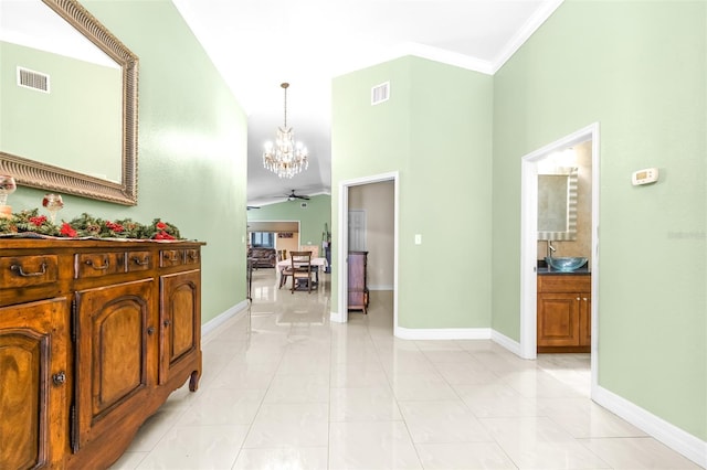 hallway featuring baseboards, visible vents, a chandelier, and a sink