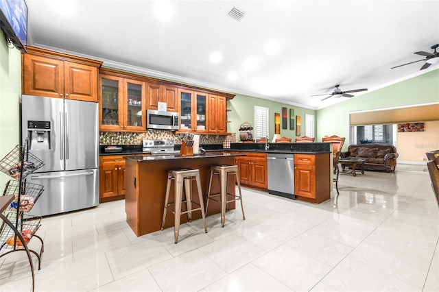 kitchen with a breakfast bar area, a center island, open floor plan, and stainless steel appliances