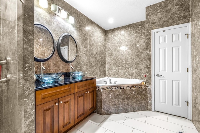 full bath with tile patterned floors, double vanity, a garden tub, and a sink