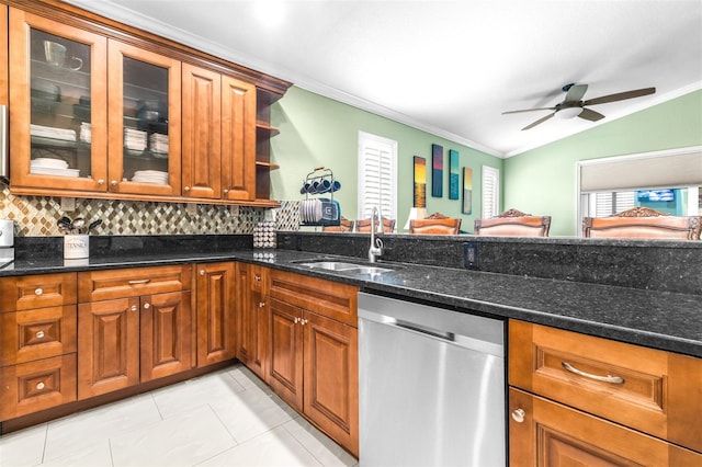 kitchen with dishwasher, dark stone countertops, brown cabinetry, and a sink