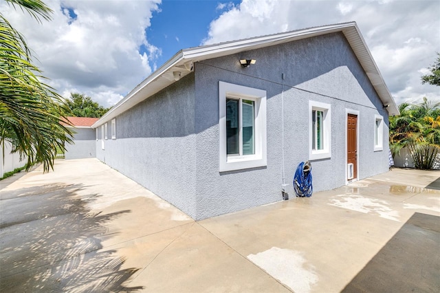 view of home's exterior featuring stucco siding, a patio, and fence