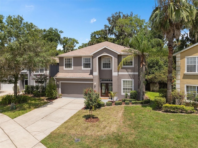 view of front facade with a front yard, a garage, and french doors