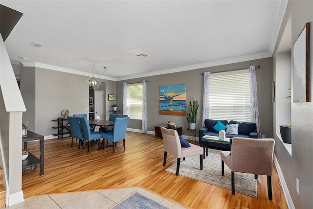 tiled living room with crown molding and a chandelier