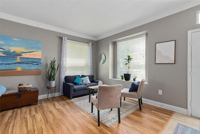 living area featuring light wood-style flooring, baseboards, and crown molding