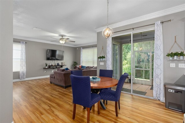 dining space with ceiling fan with notable chandelier, hardwood / wood-style floors, and ornamental molding