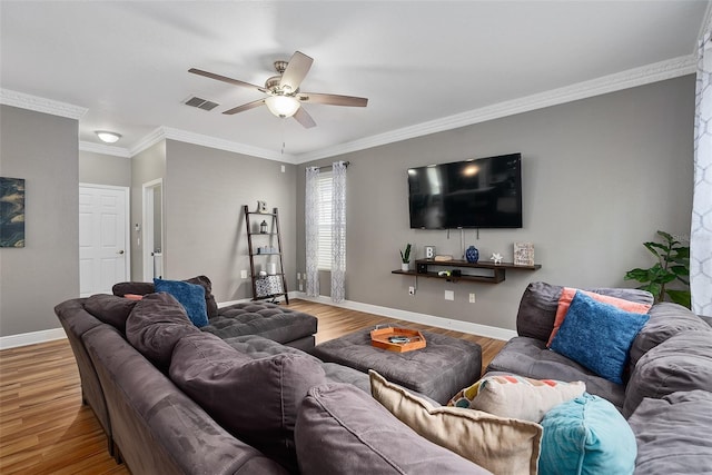 living area with ceiling fan, wood finished floors, visible vents, baseboards, and crown molding