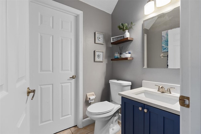 bathroom with vanity, tile patterned flooring, and toilet