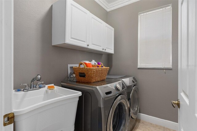 laundry room featuring separate washer and dryer, cabinets, ornamental molding, sink, and light tile patterned flooring