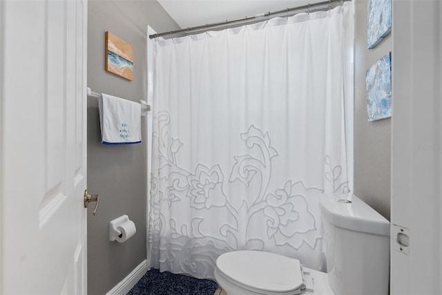 bathroom featuring baseboards and toilet