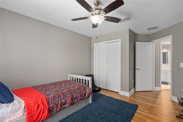 bedroom with ceiling fan, light hardwood / wood-style floors, and a closet