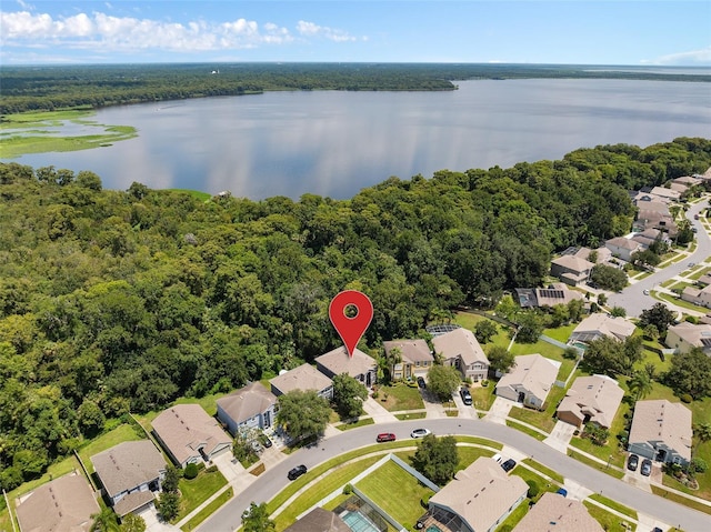 drone / aerial view with a water view, a residential view, and a view of trees