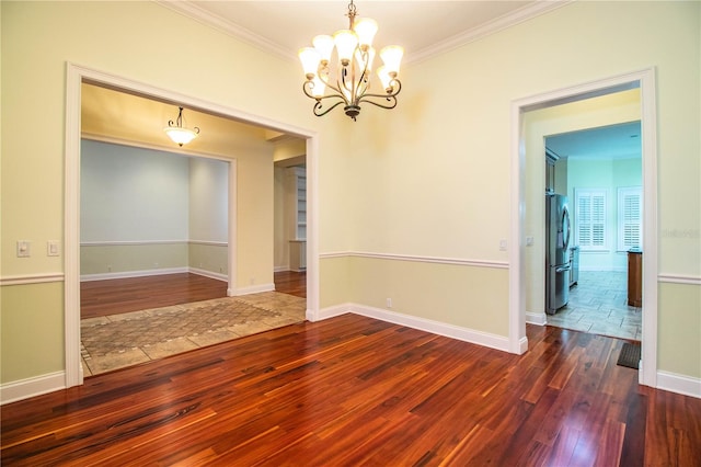 empty room featuring ornamental molding, a chandelier, and dark hardwood / wood-style floors