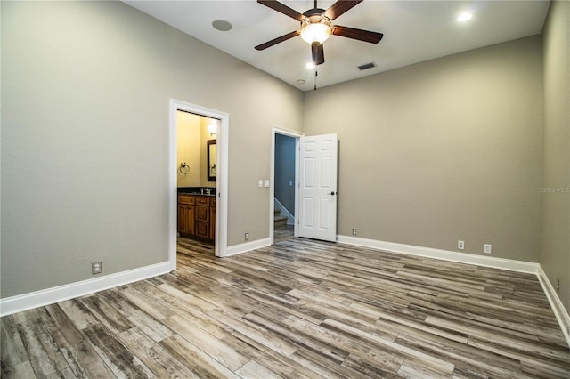 interior space featuring ceiling fan, ensuite bathroom, and hardwood / wood-style flooring