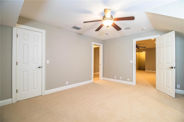 unfurnished bedroom featuring lofted ceiling, ceiling fan, and light carpet