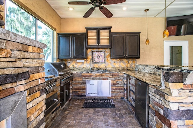 kitchen featuring decorative light fixtures, backsplash, sink, ceiling fan, and dark brown cabinetry