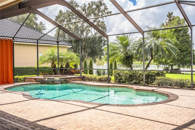 view of pool with glass enclosure, a patio, and an in ground hot tub