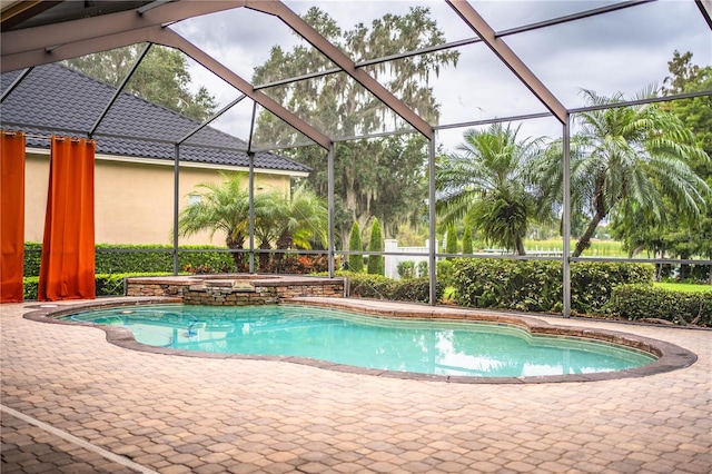 view of swimming pool featuring glass enclosure, an in ground hot tub, and a patio