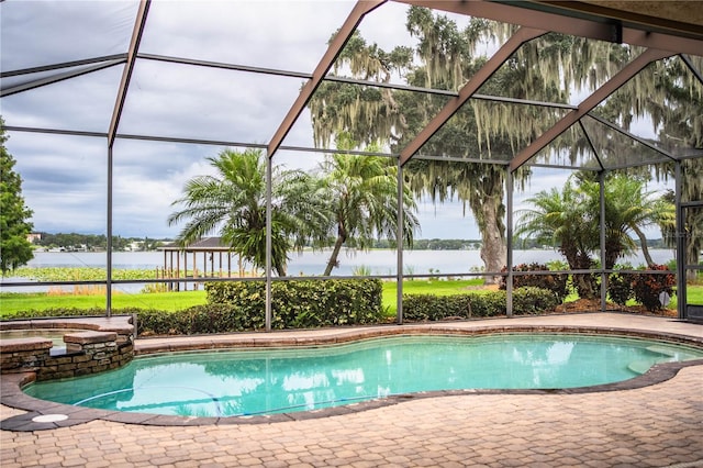 view of pool featuring a water view, a patio area, and glass enclosure