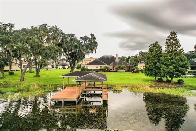 view of dock featuring a water view and a yard