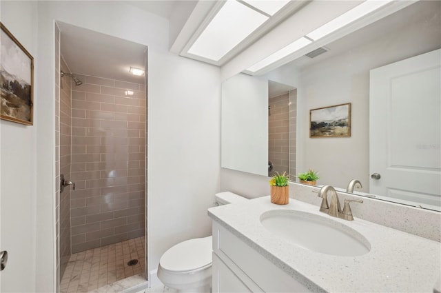 bathroom featuring tiled shower, vanity, and toilet