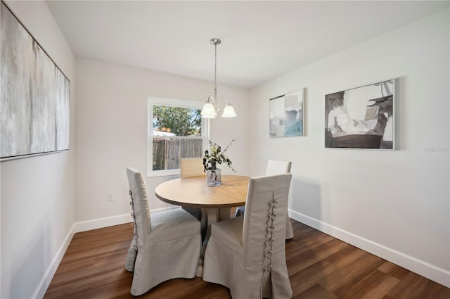 dining area featuring dark hardwood / wood-style flooring and a chandelier