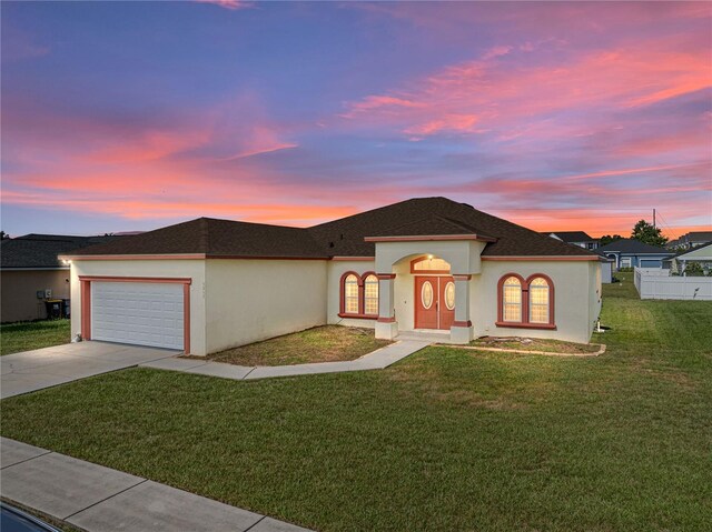 view of front facade featuring a garage and a lawn