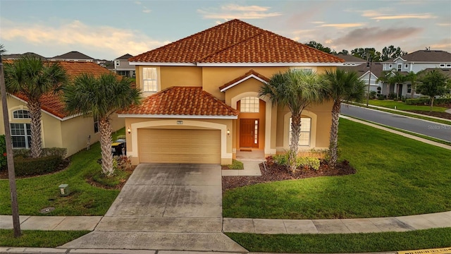 mediterranean / spanish-style home featuring a garage, a tiled roof, concrete driveway, stucco siding, and a front yard