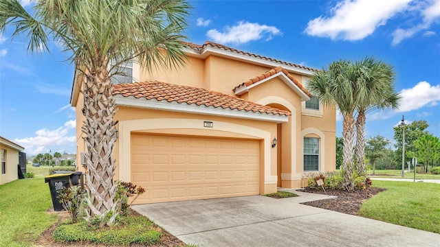 mediterranean / spanish-style house featuring concrete driveway, stucco siding, a tiled roof, an attached garage, and a front yard