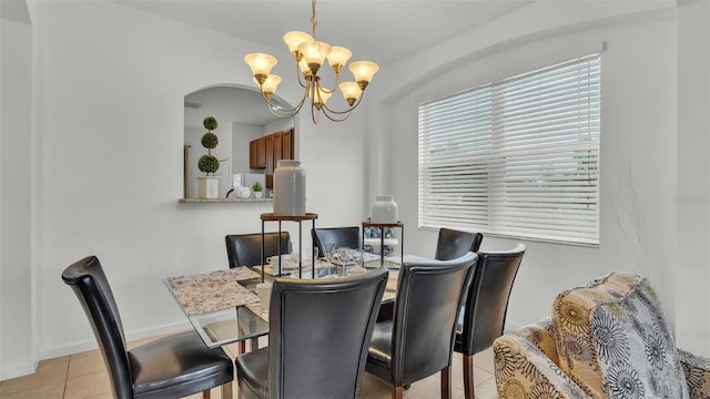 dining area with a chandelier, light tile patterned flooring, and baseboards