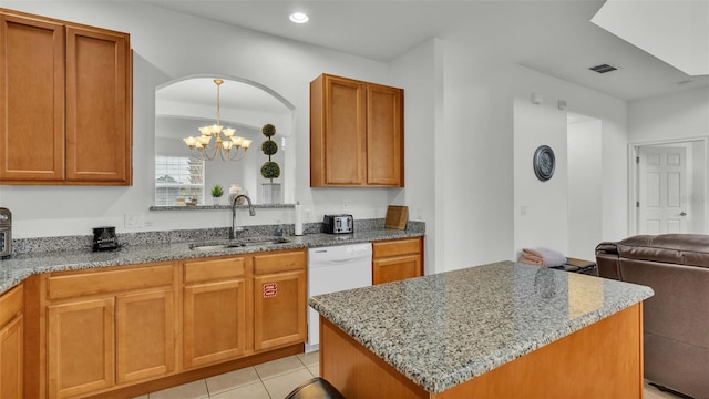 kitchen with visible vents, light stone counters, and a sink