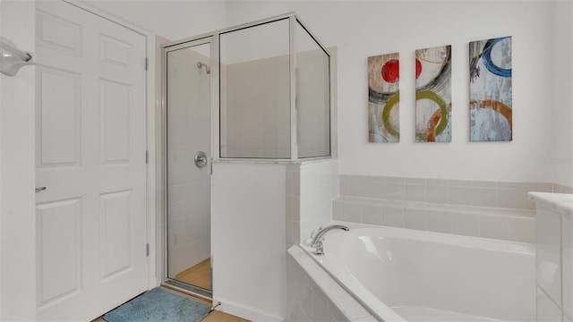 bathroom with a garden tub and a shower stall