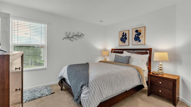 bedroom featuring baseboards and light colored carpet