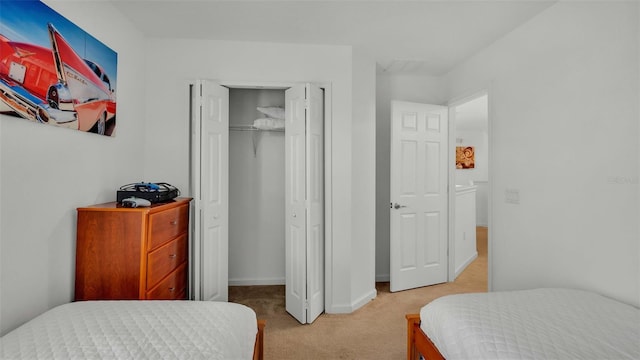 bedroom with light carpet, baseboards, and a closet