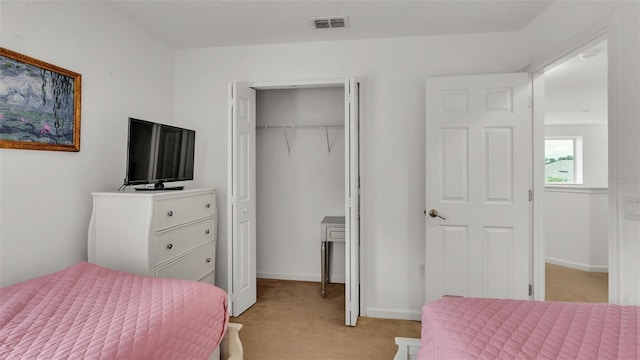 bedroom featuring light colored carpet, a closet, visible vents, and baseboards