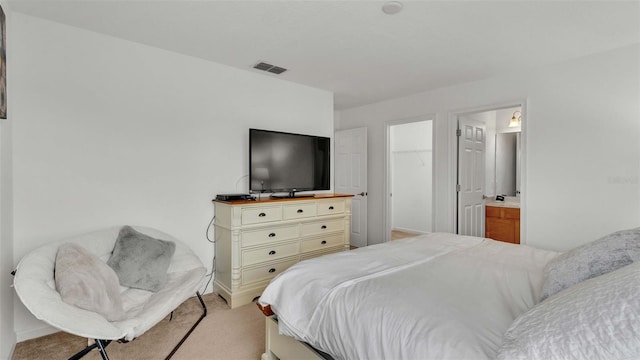 bedroom featuring a spacious closet, visible vents, and light colored carpet