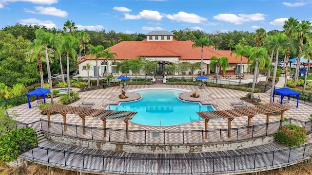 pool with a patio area, fence, and a pergola