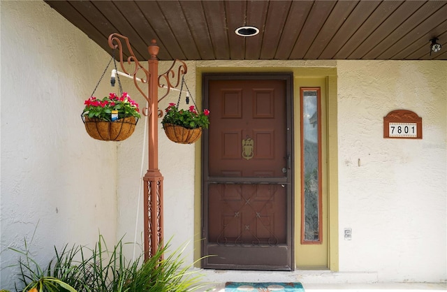 doorway to property featuring stucco siding