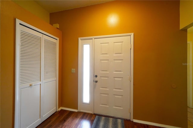 foyer entrance featuring dark wood finished floors and baseboards