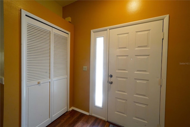 foyer entrance with dark wood-style flooring and baseboards