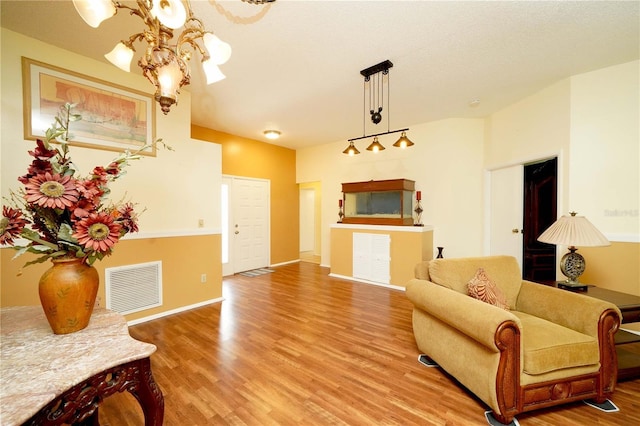 living area featuring a notable chandelier, baseboards, visible vents, and light wood-style floors