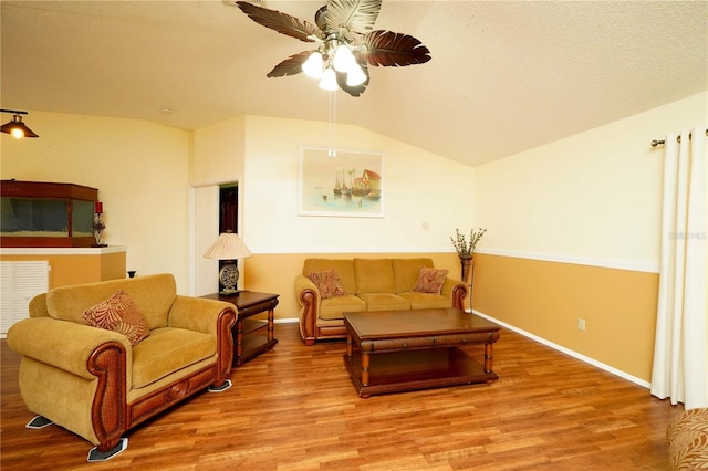 living room with hardwood / wood-style flooring, lofted ceiling, and ceiling fan