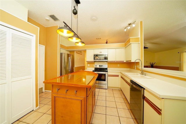 kitchen featuring appliances with stainless steel finishes, light countertops, a sink, and light tile patterned floors