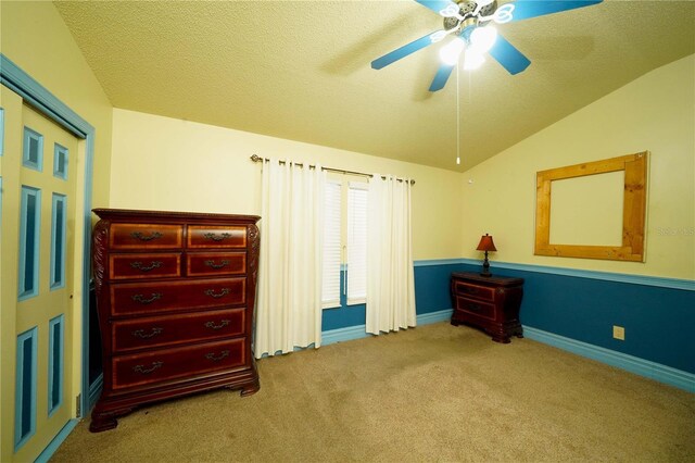 bedroom featuring a textured ceiling, ceiling fan, vaulted ceiling, and carpet